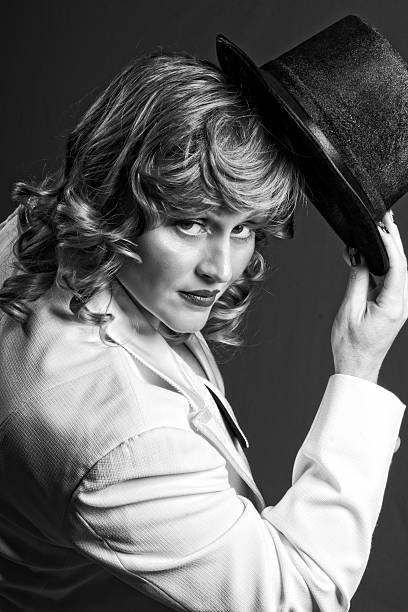 istock Blonde in white tux tipping top hat, B&W. 486882033