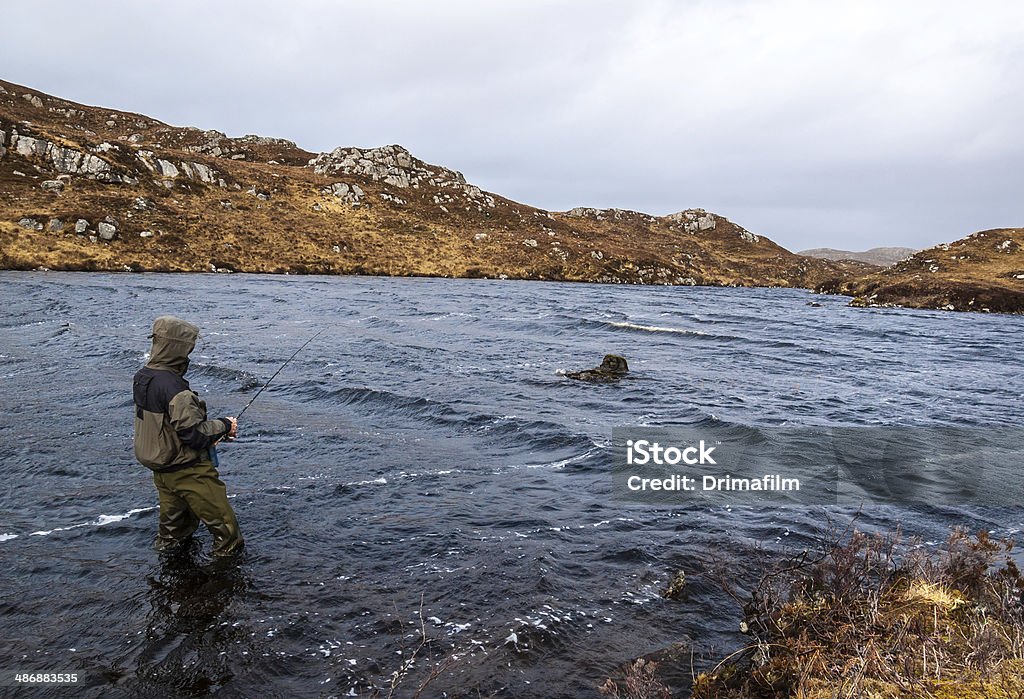 Homem pesca de truta e salmão em um lago escocês - Foto de stock de Pescaria royalty-free