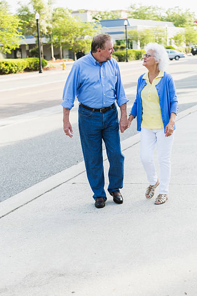 istock Senior couple holding hands walking on sidewalk 486883866