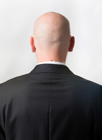 Rear view of bald man wearing suit over white background   Note to inspector: the image is pre-Sept 1 2009