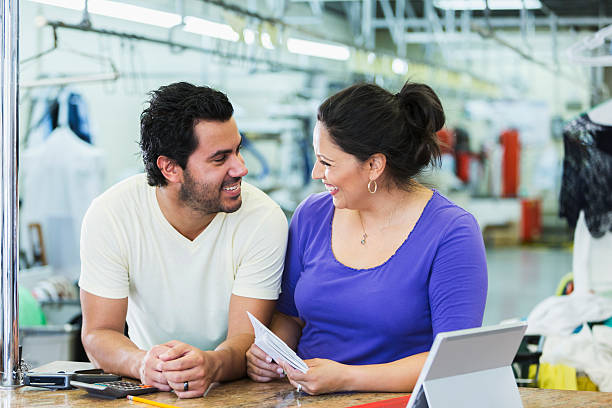 istock Hispanic small business owners, dry cleaner paying bills 486886198
