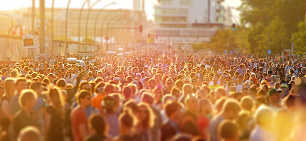 Crowd of young people at music street festival in Berlin Large crowd of young people crowding Berlin riverside streets in a sunny day during a music festival, walking, dancing and having fun. Street parties are a common way for teenagers to entertain together during the summer. Warm sunlight with lens flare. Wideangle horizontal image. berlin germany urban road panoramic germany stock pictures, royalty-free photos & images