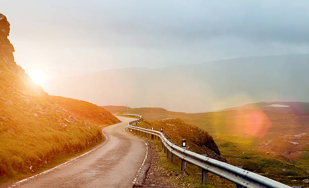istock Narrow winding road in a valley at sunset 486890616