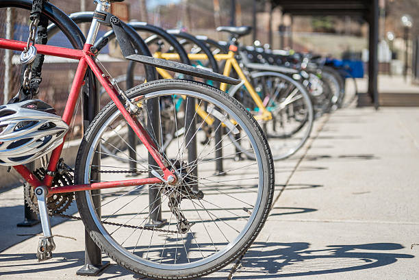 parked bicycles bicycles showing rear wheel  locked and parked at the bicycle rack in a row during day time bicycle rack photos stock pictures, royalty-free photos & images
