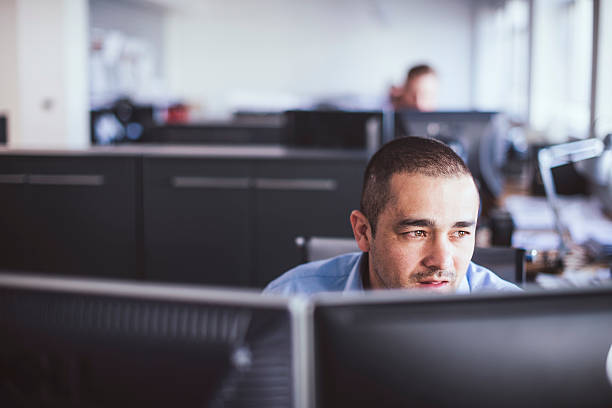 thoughtful businessman sitting at computer desk - menselijk lichaamsdeel fotos stockfoto's en -beelden