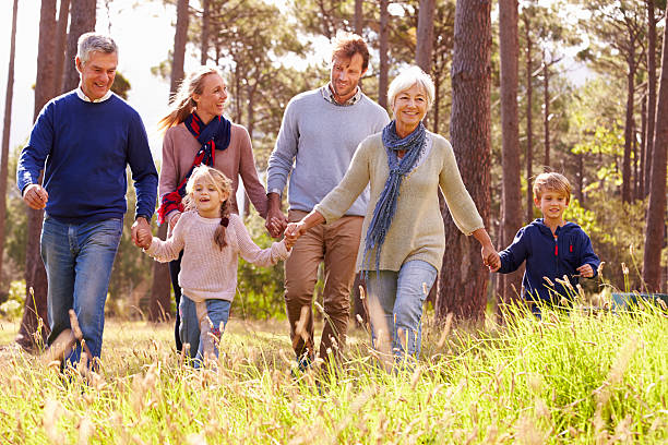 glücklich multi-generationen-familie gehen in der landschaft - family grandmother multi generation family nature stock-fotos und bilder