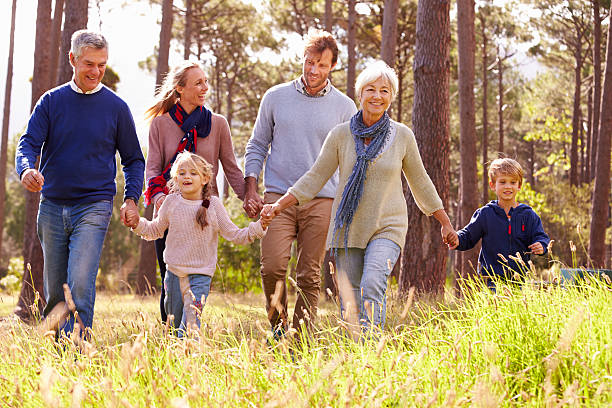 feliz multi-generation family caminando en el campo - abuelos fotos fotografías e imágenes de stock