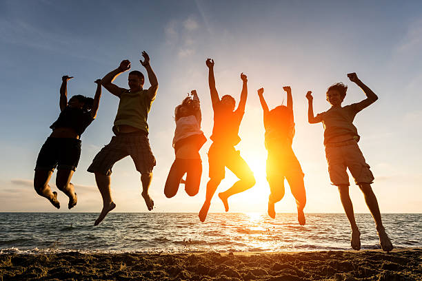 istock Silhouette of people jumping at a beach 486896857
