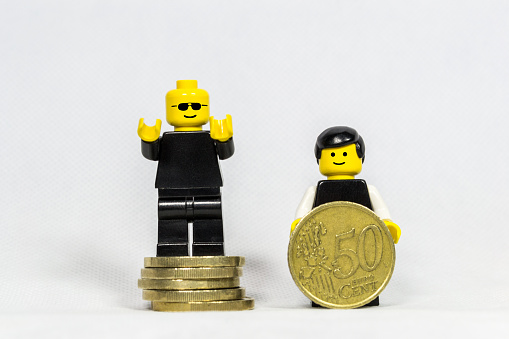 Florence, Italy - September 11, 2015: Lego mini figures takes money and smilig with white background.