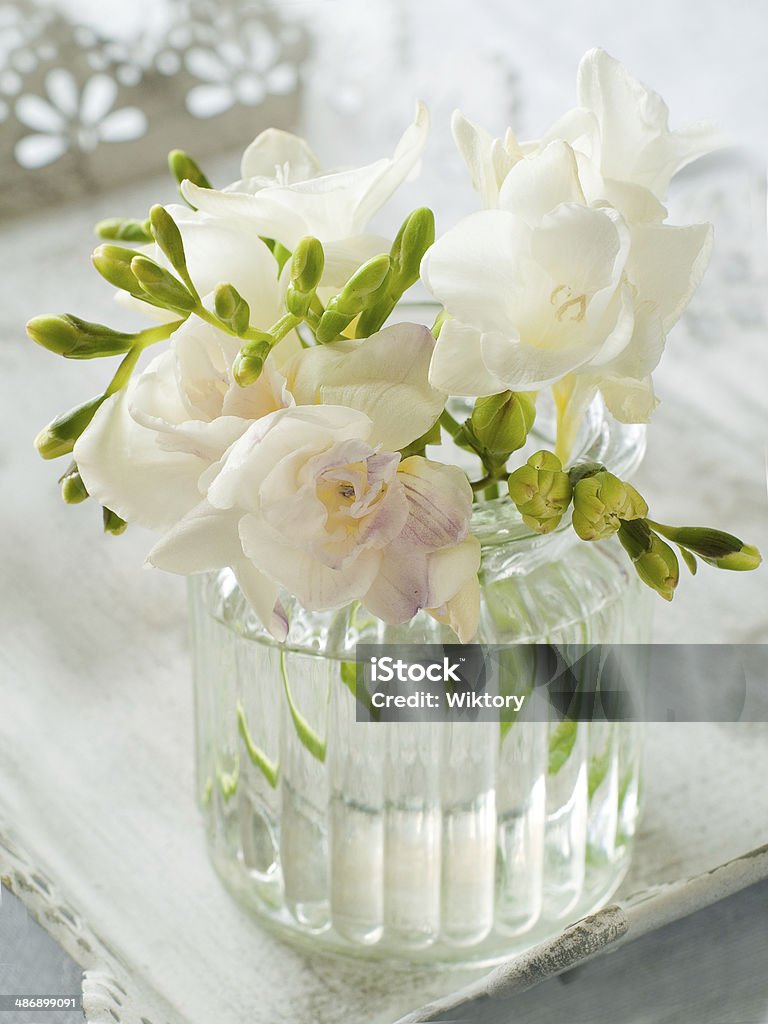 flowers Bouquet of white freesia flowers in glass vase, selective focus Arrangement Stock Photo