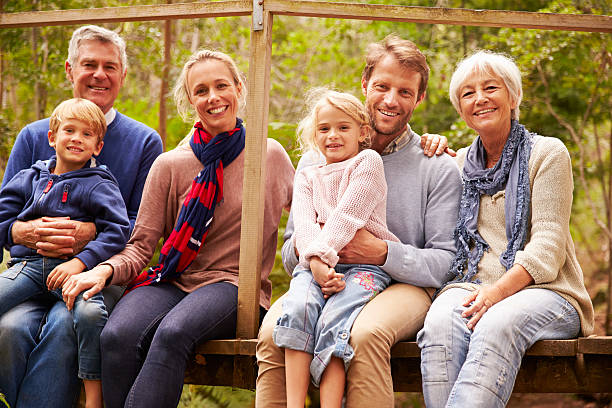 multi-generation family portrait auf einer brücke im wald - family grandmother multi generation family nature stock-fotos und bilder