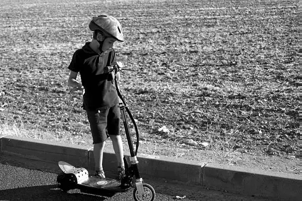 Boy with scooter in the field