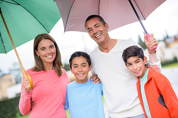 istock Family under the rain holding umbrellas 486910988