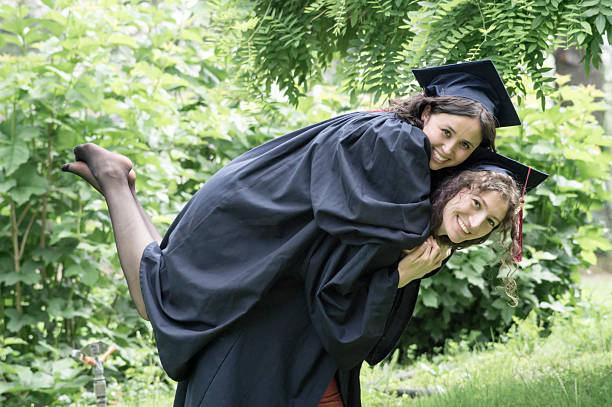istock Happy graduate girls in park 486914682