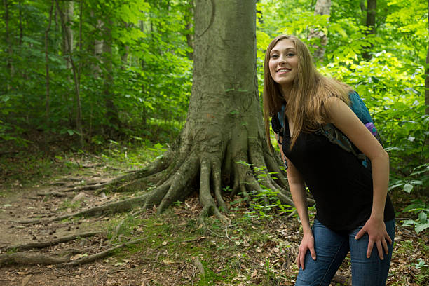 istock Smiling female backpacker in wooded forest 486914730