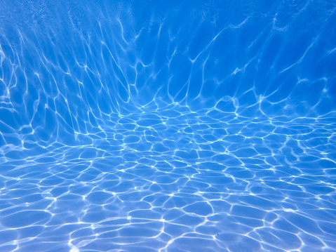 Underwater shot of a swimming pool with no one in the pool. Image is useful as a background with plenty of room for copy space or for creating composite images.
