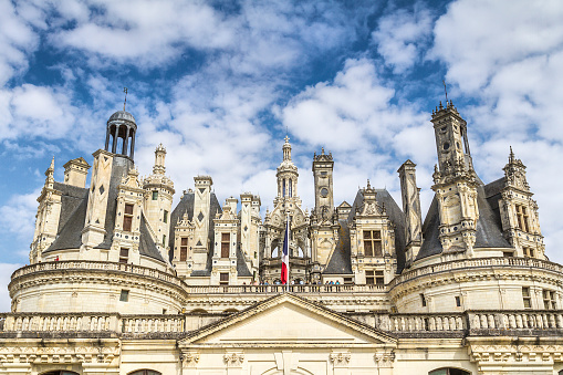 Chambord, France - August 18, 2015: Panoramic  view of Chambord Castle from the river. Built as a hunting lodge for King Francois I, between 1519 and 1539, this castle is the largest and most frequented of the Loire Valley.