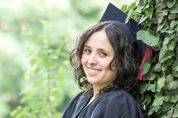 Happy graduate girl in park stock photo