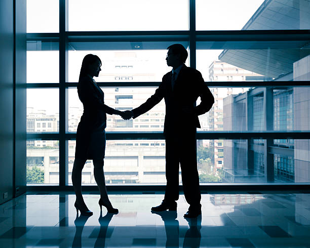 istock successful business woman and man handshaking 486916135