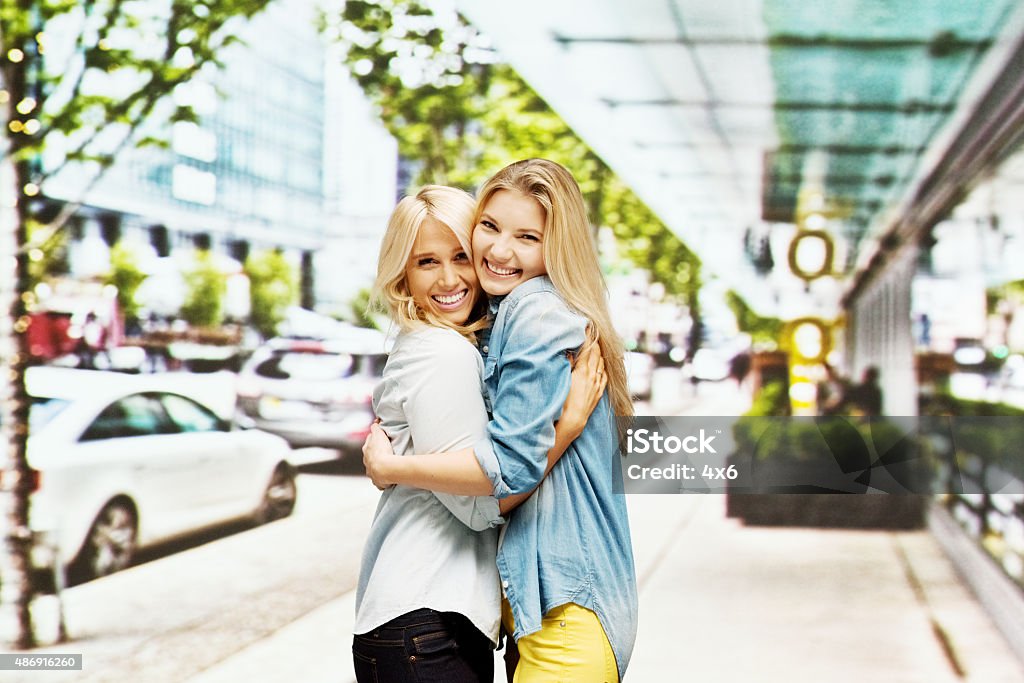Smiling women hugging at street in the city Smiling women hugging at street in the cityhttp://www.twodozendesign.info/i/1.png Cityscape Stock Photo