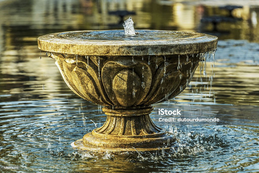 Old stone fountain Old stone fountain in a pond Fountain Stock Photo