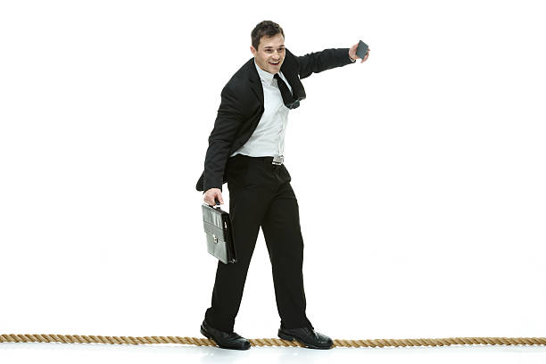 istock Smiling businessman walking on tightrope and falling 486918412