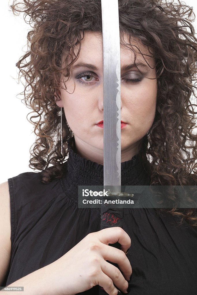 piercing woman curly girl and sword Girl - Ear super piercing woman dark hair natural brown-haired holding in her hands a katana Abstract Stock Photo