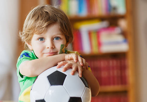 istock Little boy with football watching soccer 486920167