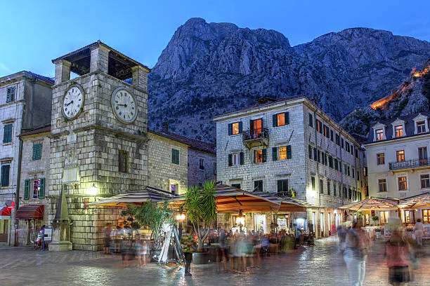 Kotor, Montenegro Scene in the medieval town of Kotor, Montenegro at twilight, featuring the Square of Arm and the clock tower near the Maritime entrance gate. montenegro stock pictures, royalty-free photos & images