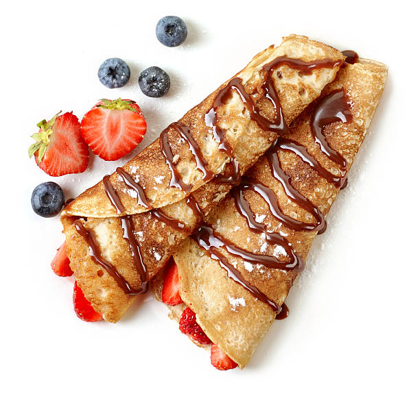 Crepes with strawberries and chocolate sauce isolated on white background