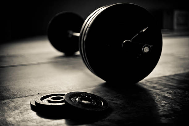 Barbell and discs in a weightlifting gym A photo of barbell and discs in a weightlifting gym clean and jerk stock pictures, royalty-free photos & images