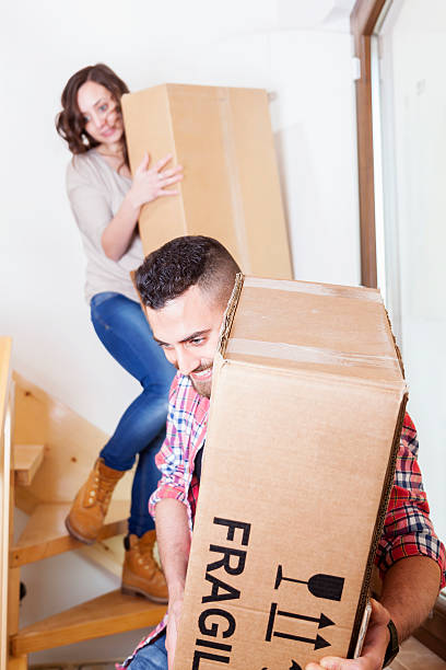 istock young couple carrying the boxes in new house 486923506