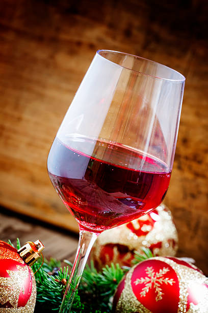 istock Red wine in the glass, tree branches and Christmas balls 486924748