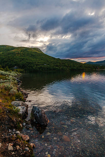 istock Sunset over a calm lake with ripples in the water. 486926540