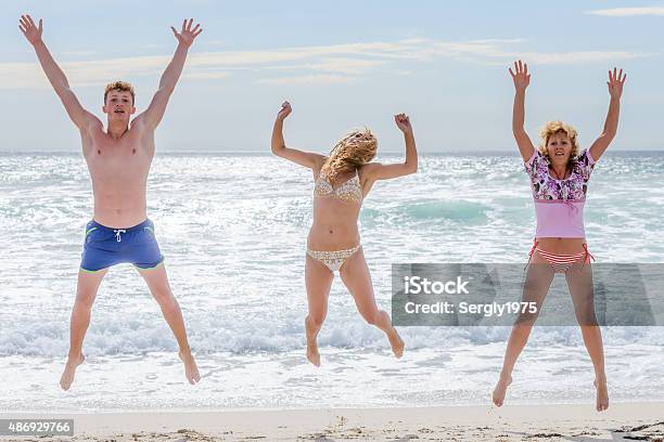 Young Men Jumping On The Beach Stock Photo - Download Image Now - 2015, Active Lifestyle, Activity