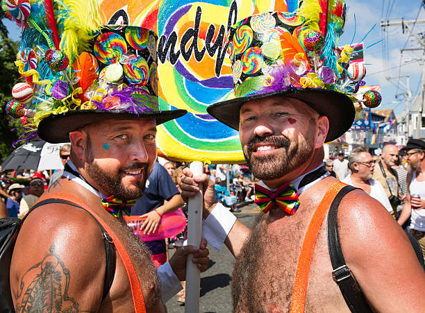 dois homens caminhando na provincetown desfile de carnaval de provincetown, massachusetts. - provincetown - fotografias e filmes do acervo