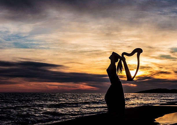 istock Girl holding a harp on sunset 486934158