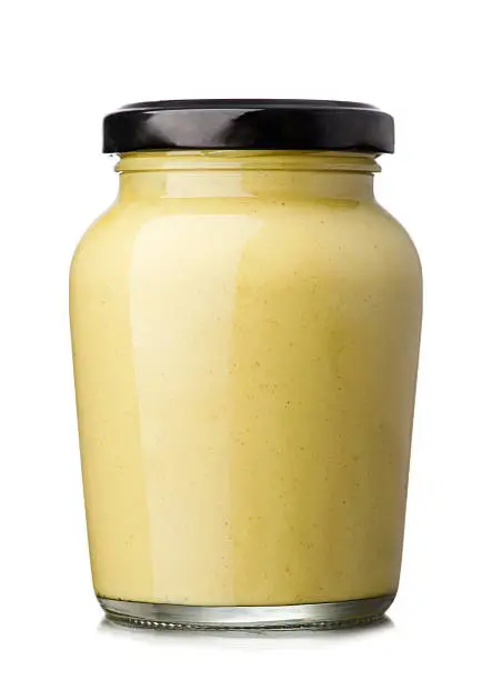 Glass jar of mustard isolated on the white background