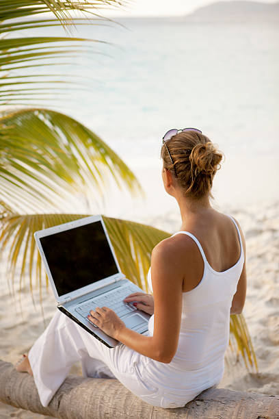 istock unrecognizable woman working on a laptop at the Caribbean beach 486935647