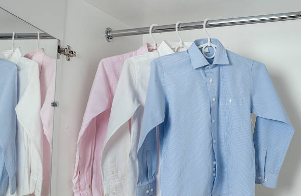 white, blue and pink clean ironed men's shirts stock photo