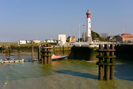 Port and lighthouse of Ouistreham at low tide in the Calvados department in the Basse-Normandie region in northwestern France.