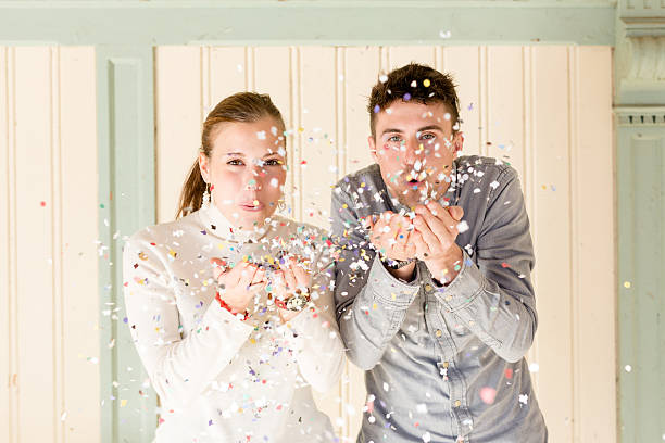 istock Happy young couple blowing confetti 486938261