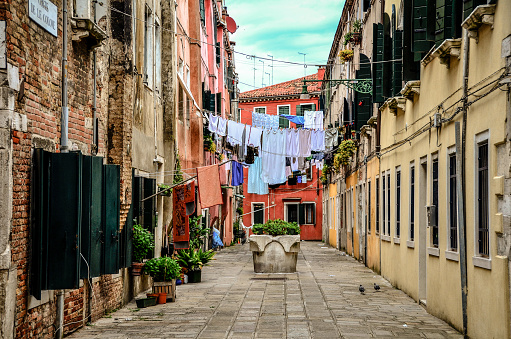 Clothes hanging across buildings to dry on a narrow alley in Venice, Italy