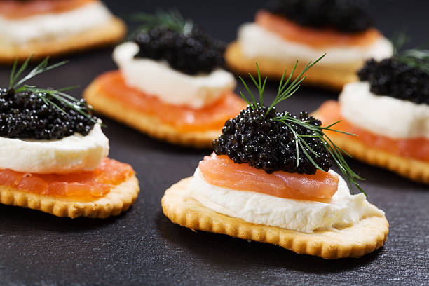 istock Black caviar served on crackers with salmon and cream cheese. 486939012