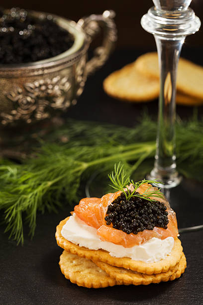 istock Black caviar on crackers with salmon and cream cheese, 486939224