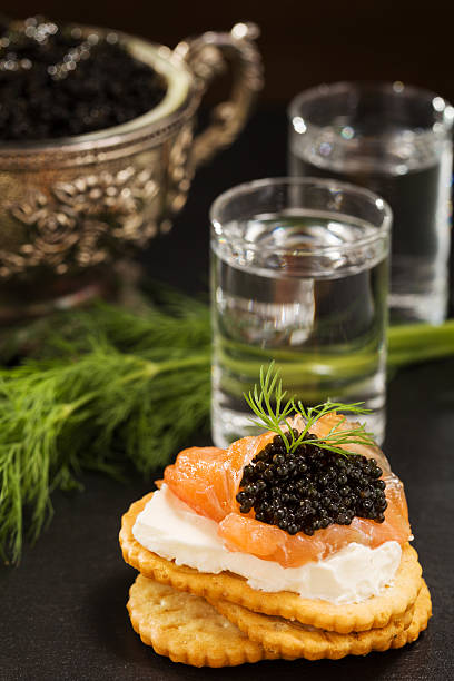 istock Black caviar served on crackers with vodka and additives 486939260