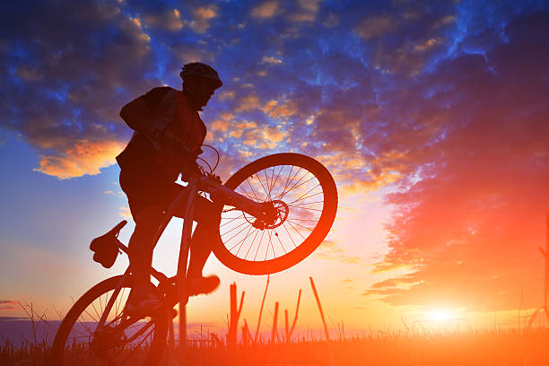 istock Silhouette of a biker and bicycle on sunset background. 486941390