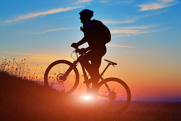 istock Silhouette of a biker and bicycle on sunset background. 486941506