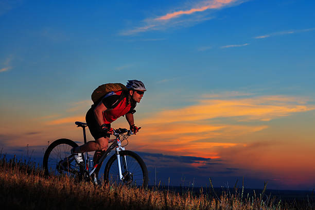 istock Silhouette of a biker and bicycle on sunset background. 486941518