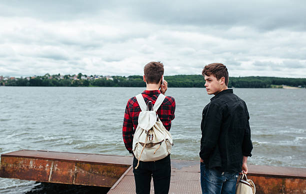 istock two young guys stand on the pier 486942108